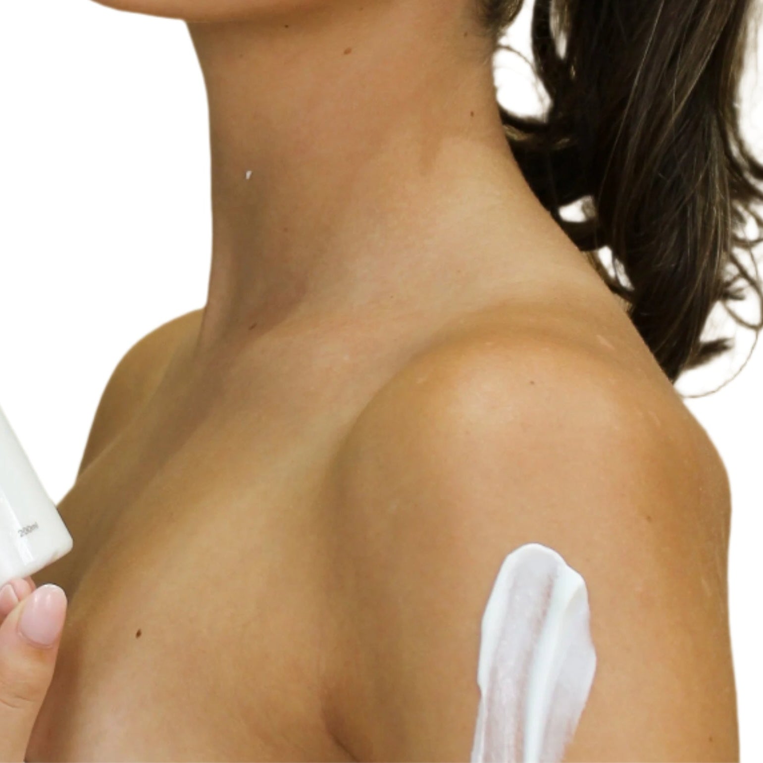 Woman applying body cream with a Shanga bottle in hand